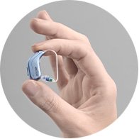 A hand holding a new hearing aid