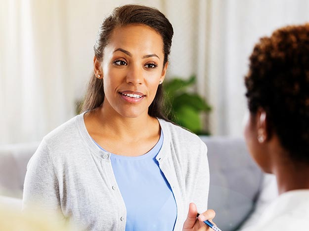 Woman consulting with an audiologist in a bright, professional setting.