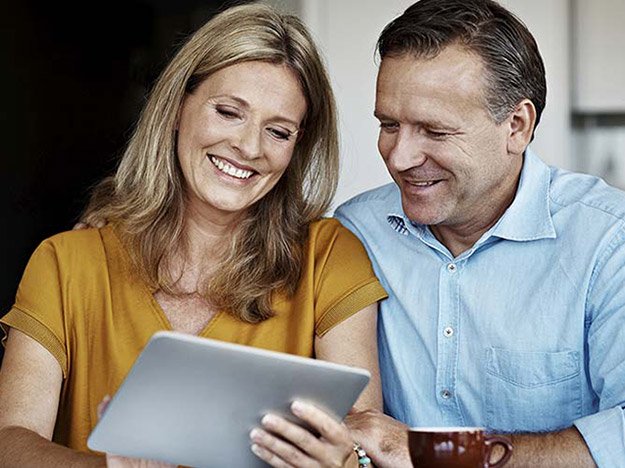 Couple reviewing hearing aid financing options on a tablet