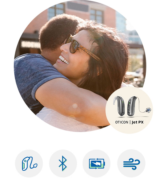 Woman smiling and embracing while wearing Oticon Jet PX™ hearing aid.