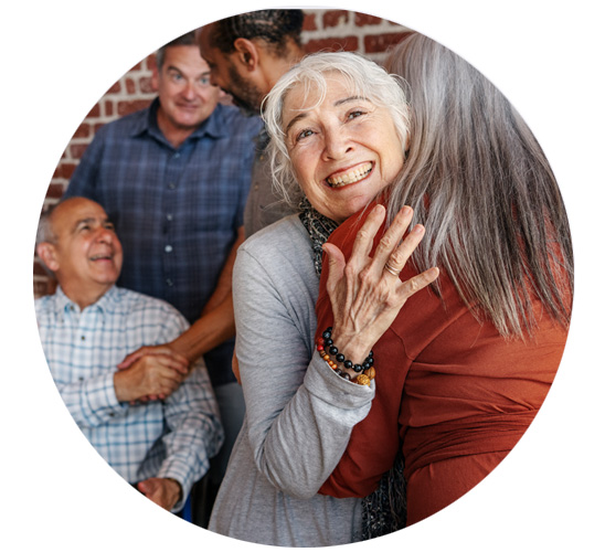 Group of people celebrating and embracing joyfully after receiving donated hearing aids