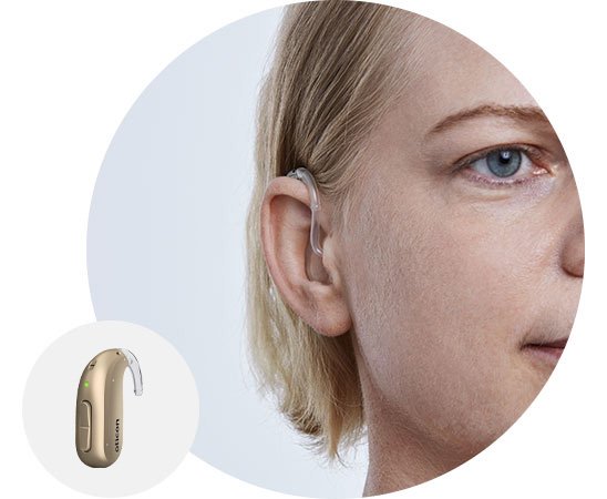 Woman wearing a behind-the-ear hearing aid with close-up of the device design.