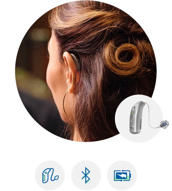 Woman using Oticon Real™ hearing aid behind her ear