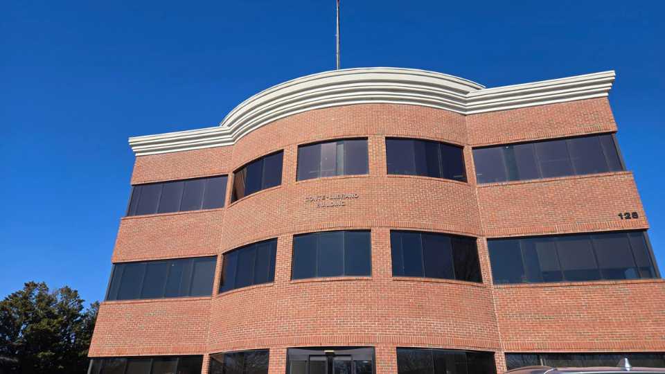 HearingLife MD Annapolis hearing care center location in a brick building against a clear blue sky.