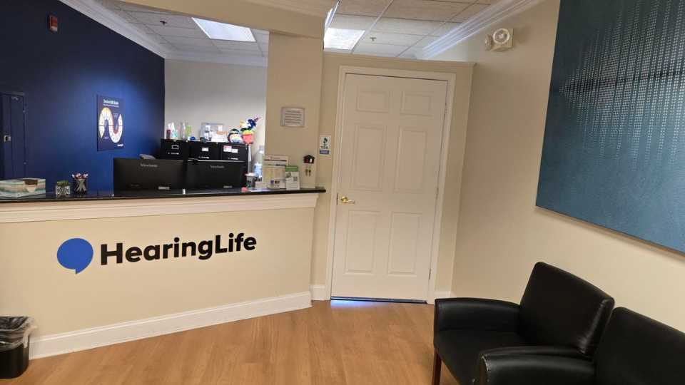 HearingLife Annapolis lobby with a reception desk, logo, seating area, and welcoming design.