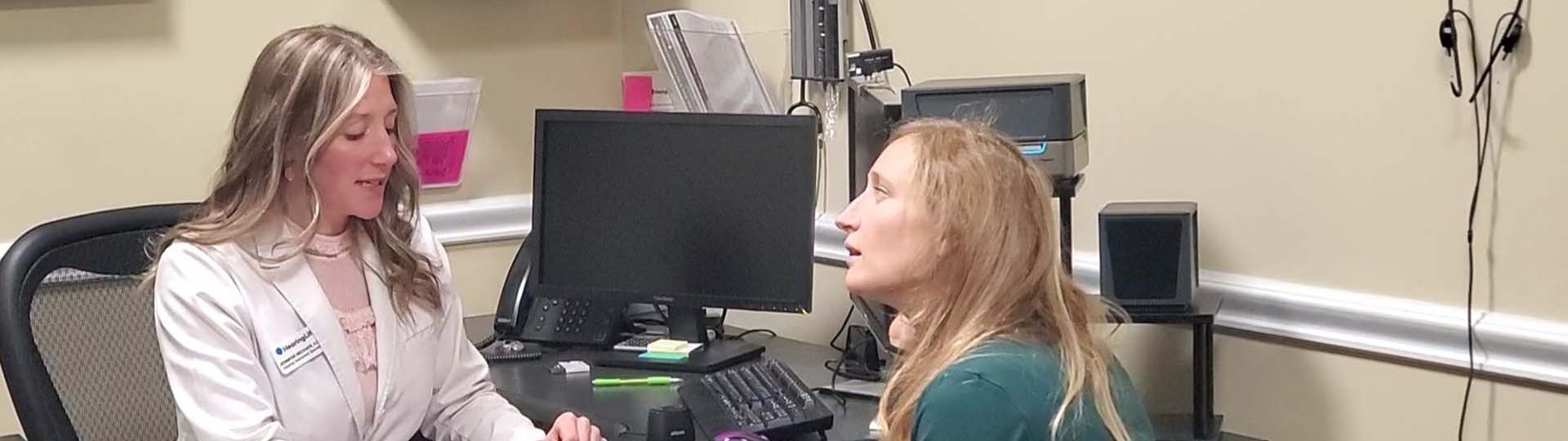 Pittsburgh-area mom receiving professional hearing aid fitting services at a hearing care clinic.