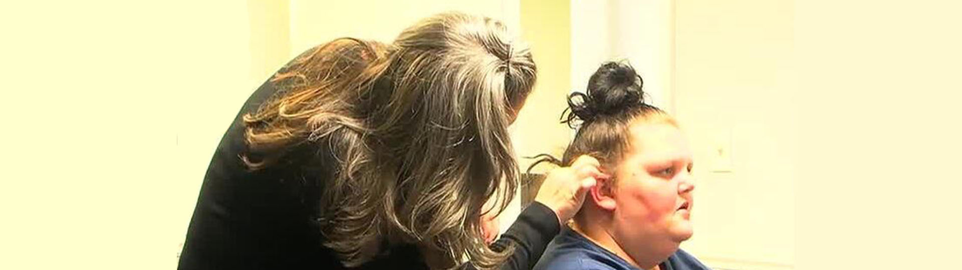 Hearing specialist fitting hearing aid for LaGrange mother at Columbus hearing care clinic.