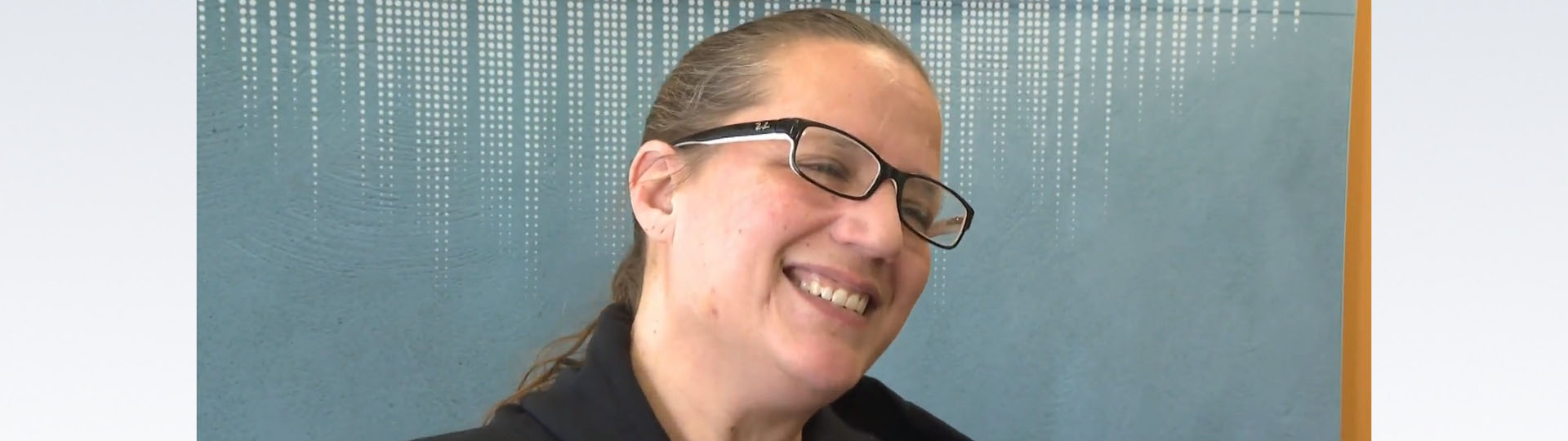 Smiling woman expressing gratitude after receiving free hearing aids.