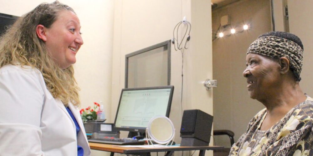 Hearing care professional consulting with a patient in a clinic setting.