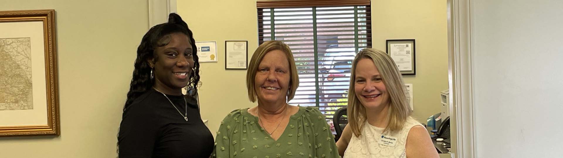 Kearie Barnes with team members at a hearing care clinic.