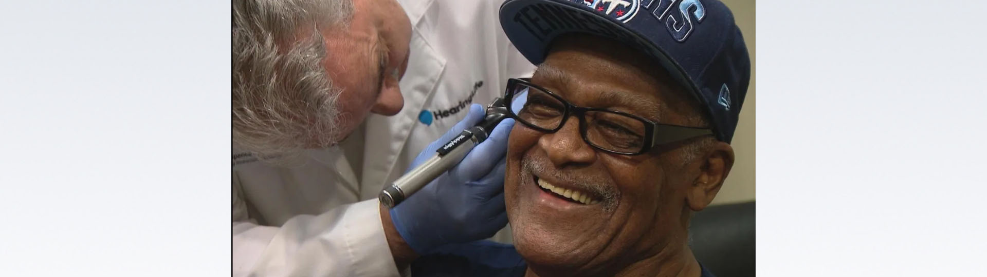 Joe Thompson, Grammy-winning singer, being fitted for free hearing aids by a hearing specialist.