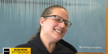 Smiling woman expresses gratitude after receiving complimentary hearing aids.