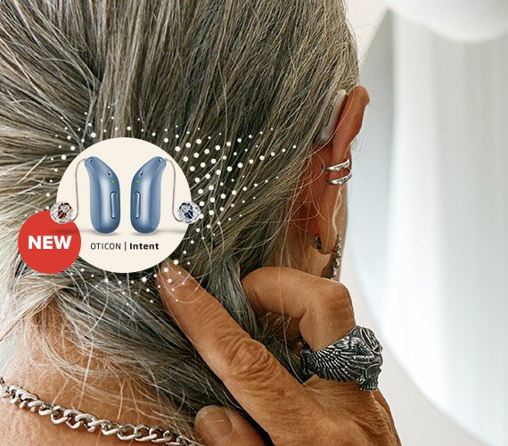 A man wearing a blue Oticon Intent hearing aid