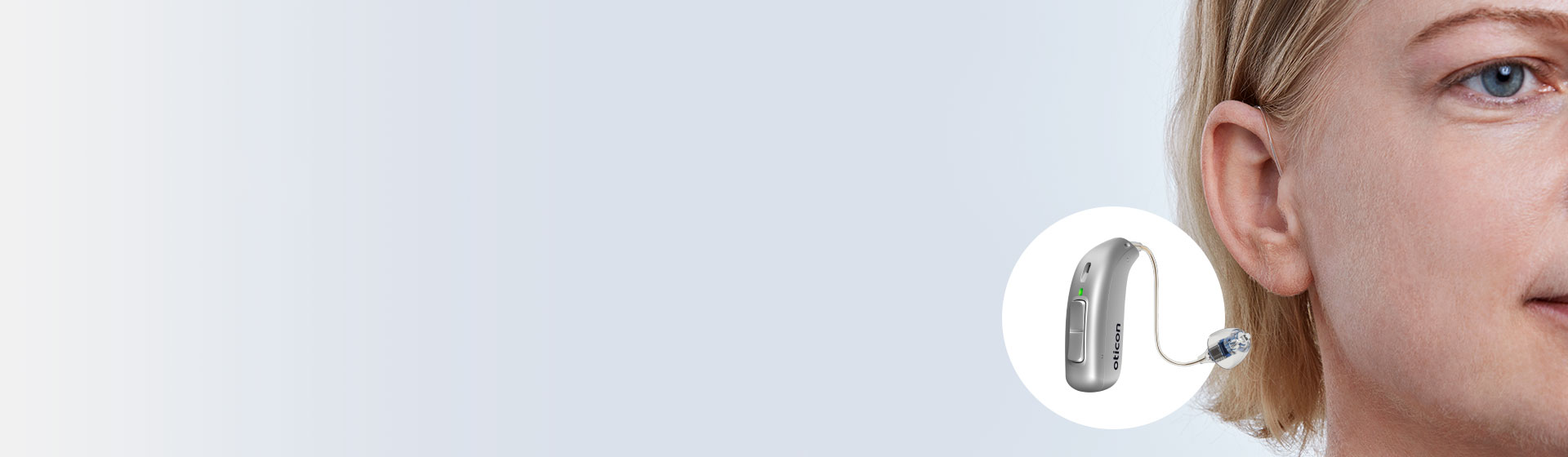 Hearing aid positioned discreetly behind a man’s ear with close-up of the device highlighting its sleek design.