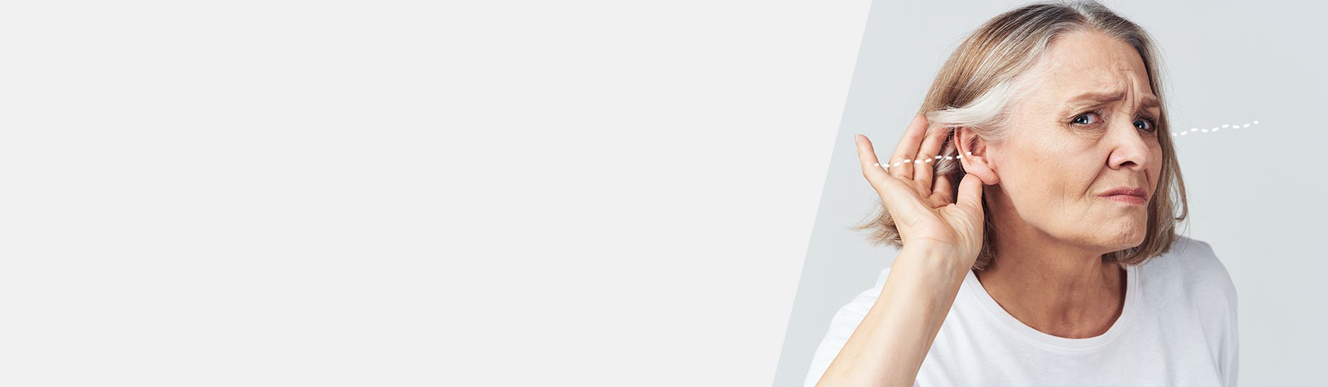 Woman with bilateral hearing loss holding hand to ear.