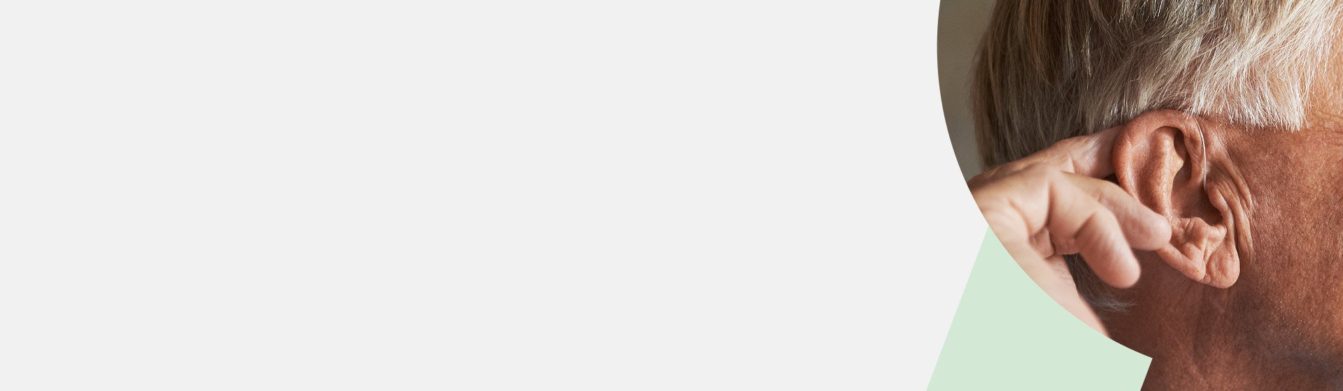 Elderly man touching his ear, highlighting hearing health and care.