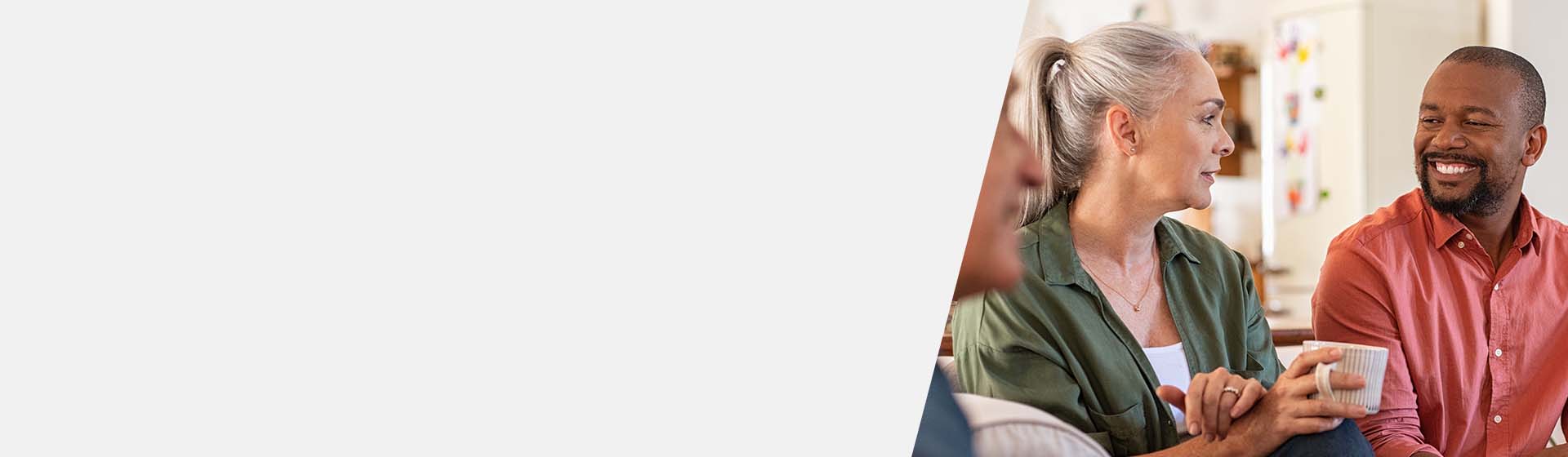 People discussing low-frequency hearing loss over coffee in a home setting.