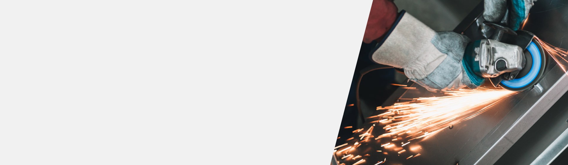 Hand wearing protective glove using a loud angle grinder, emitting bright sparks during metal work.