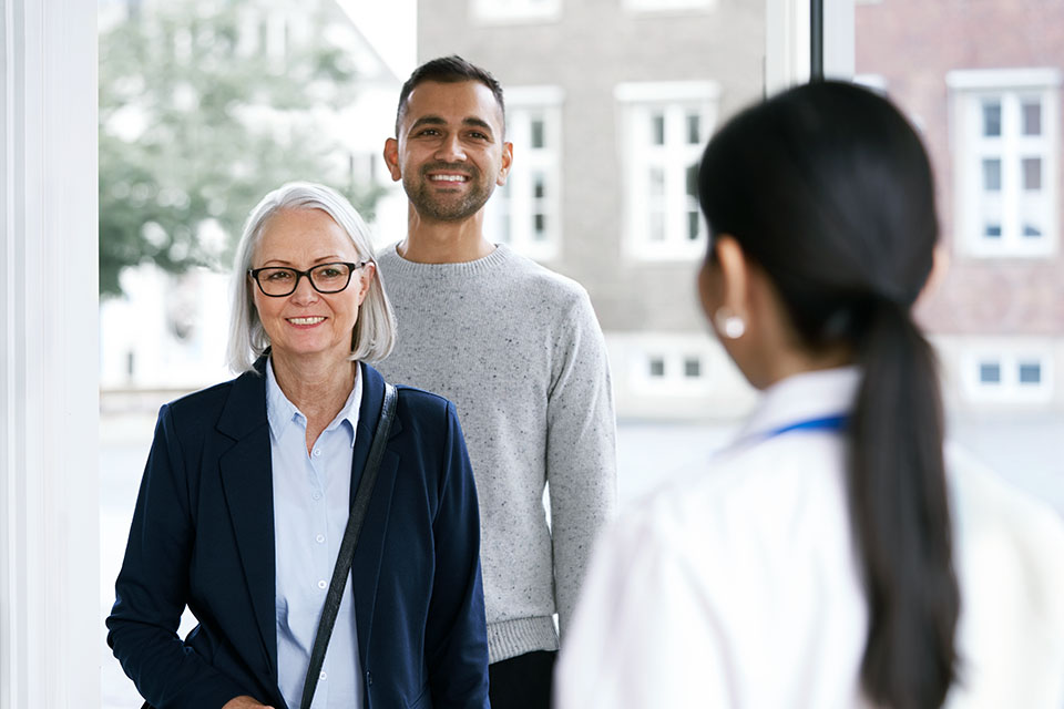 Image shows smiling people entering a hearing clinic