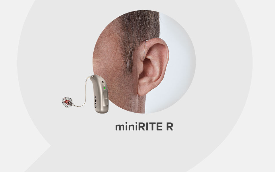 A close-up of a person's ear with a hearing aid labeled 