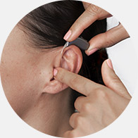 Woman being fitted with a behind-the-ear hearing aid.