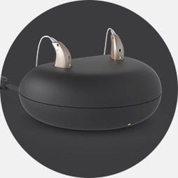 Charging pod with two modern hearing aids placed on top