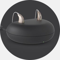 Charging pod with two modern hearing aids placed on top