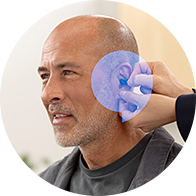 Hearing care professional adjusting hearing aid for a client