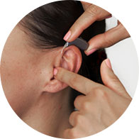 Woman being fitted with a hearing aid by a hearing care professional