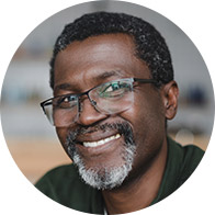 Smiling man wearing glasses in a professional setting.