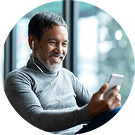 Man wearing earphones and looking at his phone.