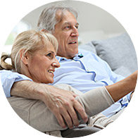 Older couple embracing on a couch, conveying warmth and connection.