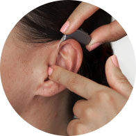 Placing a small hearing aid behind the ear