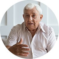 Elderly man gesturing while engaging in conversation