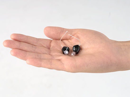hand holding Oticon Zeal™ hearing aids