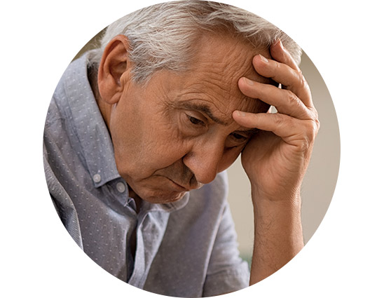 Man with gray hair resting his forehead in his hand, conveying worry or deep thought.
