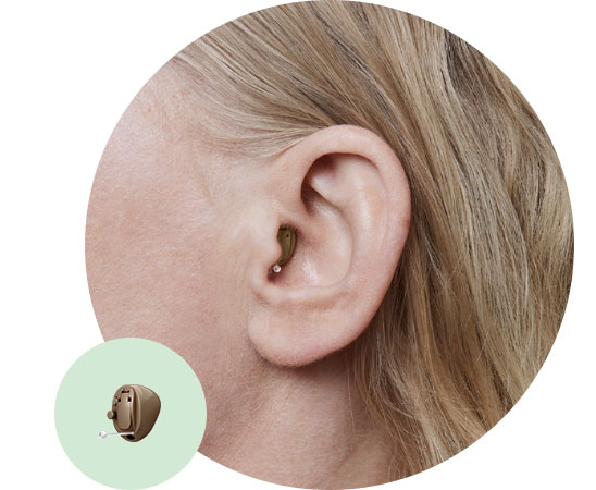 Completely-in-the-canal hearing aid placed discreetly in a woman’s ear.