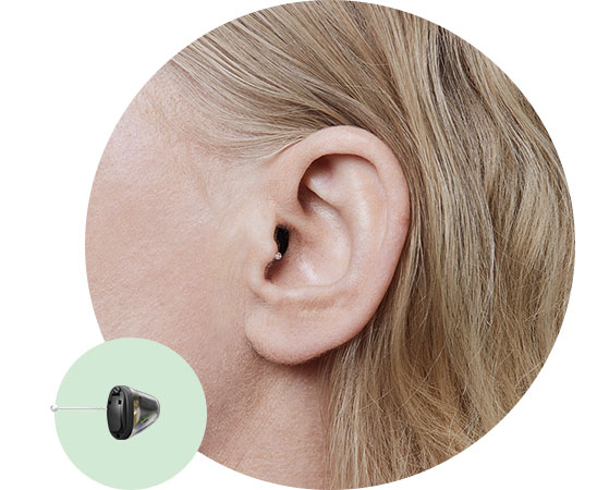 Close-up of an ear wearing an invisible-in-the-canal hearing aid, shown alongside a detailed view of the device.