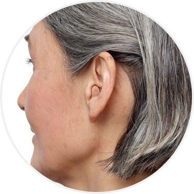 Appareil auditif intra-canal porté par une personne aux cheveux gris.