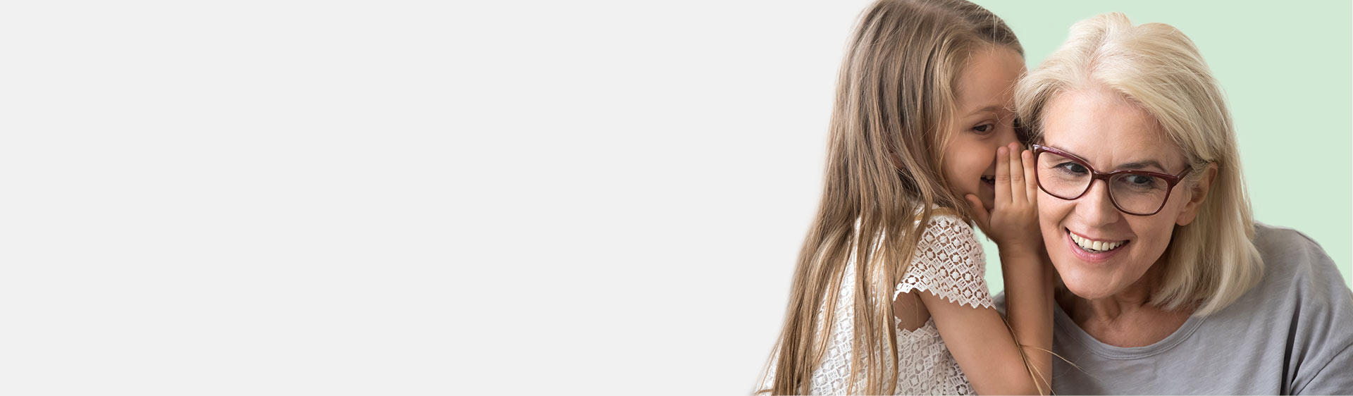 Une petite fille chuchote à l’oreille d’une femme.